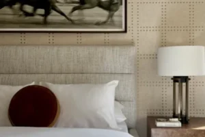 Bedroom with equestrian artwork and upholstered wall